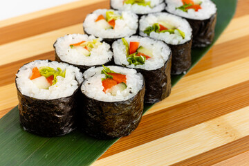 Maki Sushi Rolls set on wooden bamboo board. Japanese traditional Cuisine. White background.