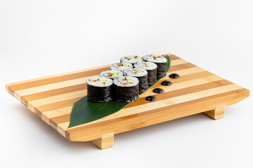 Maki Sushi Rolls set on wooden bamboo board. Japanese traditional Cuisine. White background.