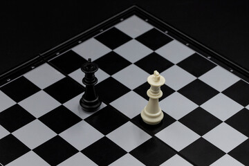 Black and white king on chessboard. Victorious and defeated king figure. Chess figurine order....