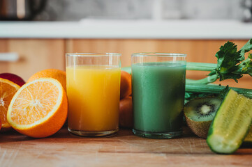 Orange juice and healthy green juice with fresh fruit on a wooden table