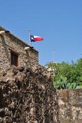 Side wall of the Alamo with Texas Flag