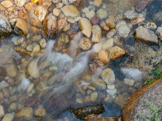Water from a stream flowing over a bed of rocks