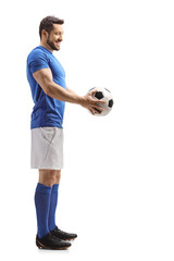 Footballer in a blue top and white shorts giving a soccer ball