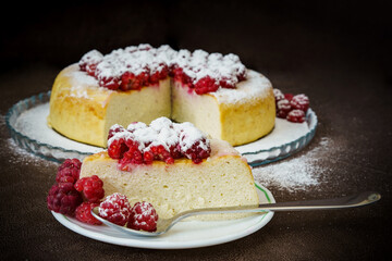 slice of curd cake with raspberries and powdered sugar