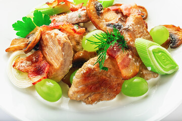 Pork with mushrooms, grapes, leek and parsley. High key. Selective focus.