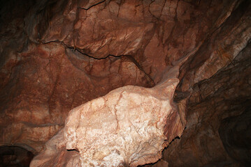 A cave with stalactites and stalagmites in an underground cave, rocks.