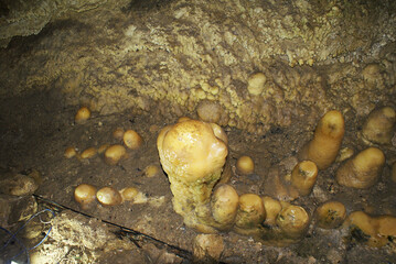 A cave with stalactites and stalagmites in an underground cave, rocks.