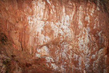 A cave with stalactites and stalagmites in an underground cave, rocks.
