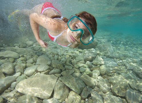 Young girl swims in the sea.

