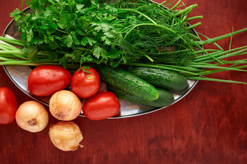 healthy food - fresh vegetables and greens on a wooden background, greens, onion and tomatoes