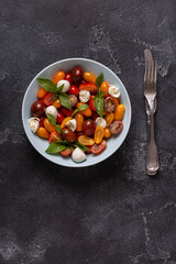 Italian caprese salad with tomatoes, mozzarella cheese, basil, olive oil.