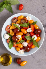 Italian caprese salad with tomatoes, mozzarella cheese, basil, olive oil.