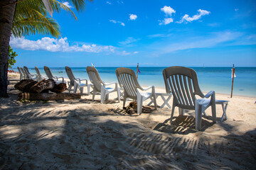 Empty chair on white sand beach. Hotel facility with no tourist. Tropical island holiday destination.