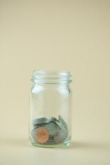 Close up of Thai coins in glass jar.