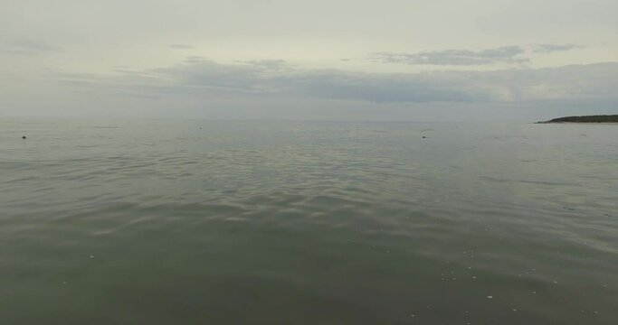 Dark Sand Beach with lots of Sea Weed and Pieces of Wood at Dusk in Anticosti Island, Canada