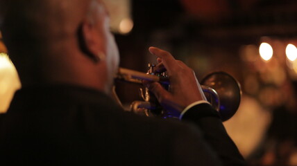 man playing trumpet from back