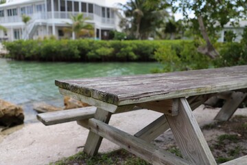 Fototapeta premium Wooden picnic bench on banks of lake
