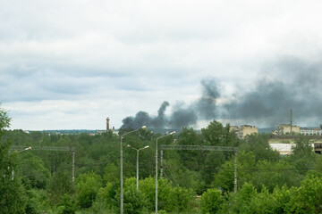 
smoke from pajar in the industrial area view behind trees