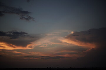 Sunset or sunrise sky. Dense clouds backlit by pink sunlight in the evening or morning sky.