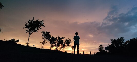 silhouette of a man walking on a mountain sunset