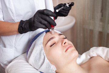The beautician performs the procedure micronidling, dermopen in the beauty salon. Delivery of medicinal substances with the help of multi-needle therapy, replacement of mesotherapy, acne
