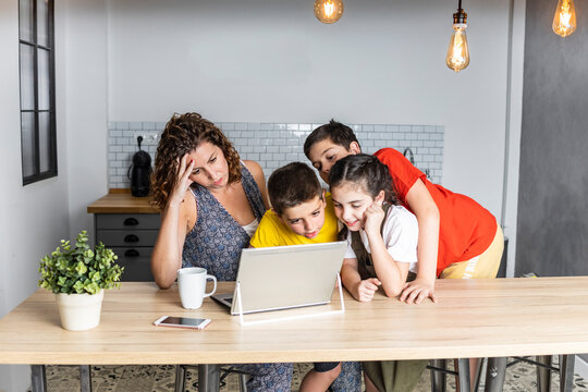 Stressed mother trying to work at home wiyh three children