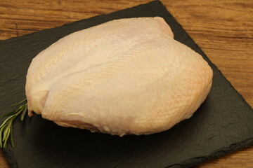 Raw whole chicken breast with skin