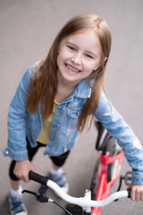 Fototapeta na wymiar Cute little girl with bike, view from above