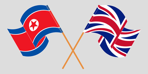 Crossed and waving flags of North Korea and the UK