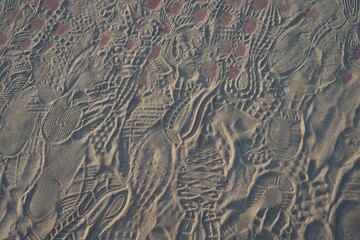 Imprint of shoes on sand. Many footprints. Background photo texture