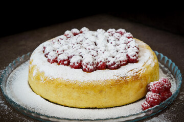 Slice of curd cake with raspberries and powdered sugar
