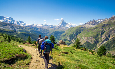 Fototapeta na wymiar Encouraged tourists going to Matterhorn