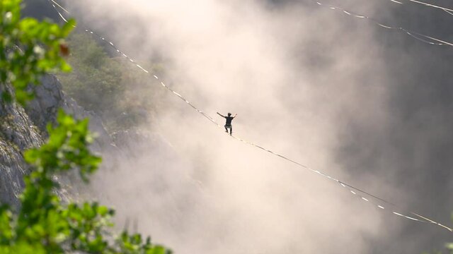 The fall of the tightrope walker. Highliner hanging on a sling. A man catches a balance on a stretched rope. Safety in the Highline.