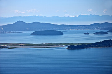 This seascape image is of ocean, islands and mountains.  The islands are some of the San Juan Islands off the coast in Washington state.  Taken from a high vantage point.