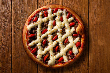 Brazilian pizza with meat, tomato and cream cheese. top view on wood background, close up. Traditional Brazilian Pizza