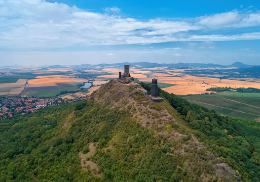 Aerial view of two stone towers,  ruins of medieval castle Hazmburk, Hasenburg built on top of the mountain peak, surrounded by agriculture czech landscape. Tourist point, castles of western Bohemia