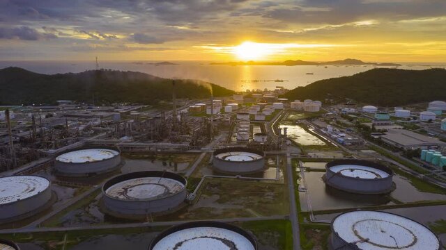 4K UHD resolution drone Hyperlapse of oil refinery plant chemical factory and power plant with many storage tanks and pipelines at sunset.