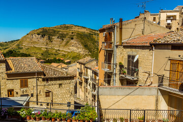 Limestone hill with dipping strata viewed across the rooftops of Petralia Sottana in the Madonie...