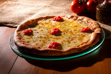 Pizza Margherita on wood background. Pizza Margarita with Tomatoes, Basil and Mozzarella Cheese close up. Traditional Brazilian Pizza.