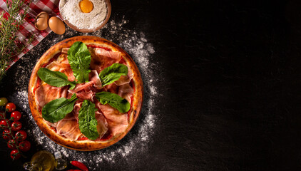 Brazilian pizza with prosciutto and arugula. Top view on black concrete background, close up. Traditional Brazilian Pizza