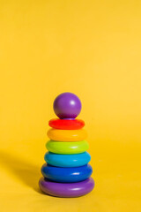 Toy pyramid on a yellow isolated background. Vertical orientation
