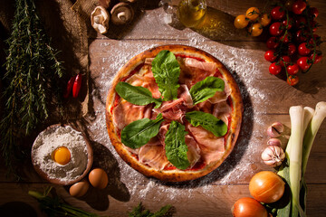 Brazilian pizza with prosciutto and arugula. Top view on wood background, close up. Traditional...
