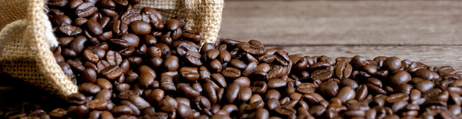 Roasted arabica coffee beans background on wooden table.Arabica coffee is the world's most popular type of coffee.