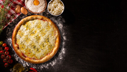 Pizza four cheese,. Top view on black concrete background, close up. Traditional Brazilian Pizza.