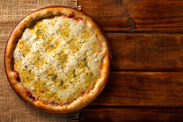 Pizza four cheese,. Top view on wood background, close up. Traditional Brazilian Pizza.