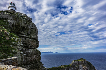 Fototapeta premium Old lighthouse (1857) sits on top of cliffs of Cape Point in Cape of Good Hope Nature Reserve on southern tip of Cape Peninsula in South Africa. The Atlantic and Indian oceans converge at Cape Point.