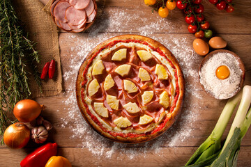 Turkey breast, pineapples and cream cheese Pizza. Top view on wood background, close up. Traditional Brazilian Pizza with smoke.