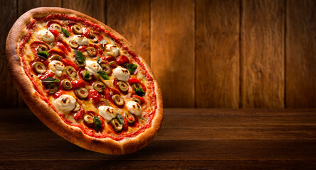 Brazilian pizza with tomato, cream cheese, olive and basil. Side view on wood background, close up. Traditional Brazilian Pizza