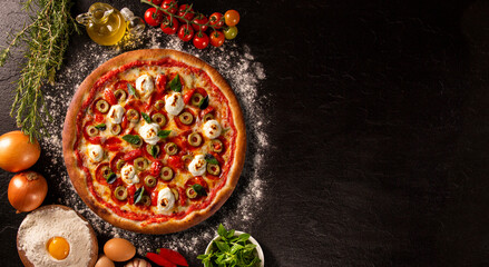 Obraz na płótnie Canvas Brazilian pizza with tomato, cream cheese, olive and basil. Top view on black concrete background, close up. Traditional Brazilian Pizza