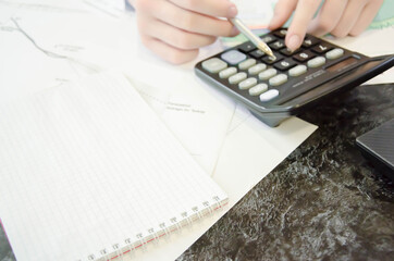 Close up Business woman using calculator and laptop for do math finance on wooden desk in office and business working background, tax, accounting, statistics and analytic research concept